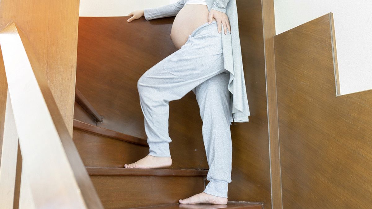 Ibu Hamil sedang Naik Tangga